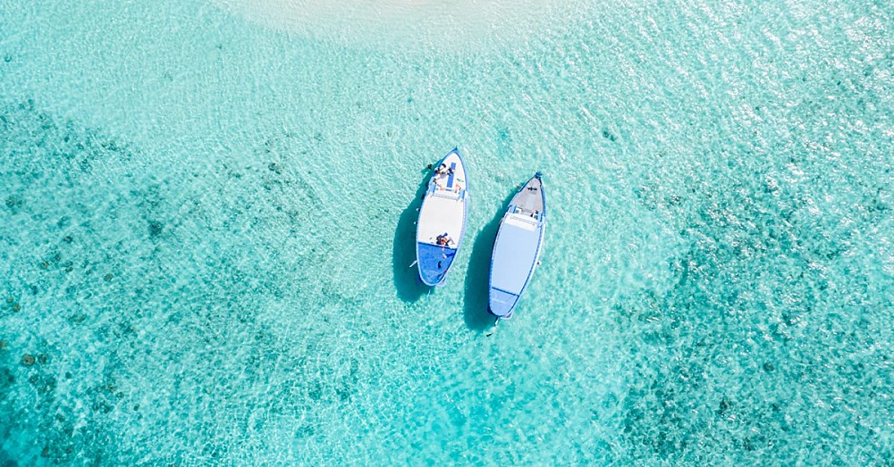 Two boats, moored off a private beach