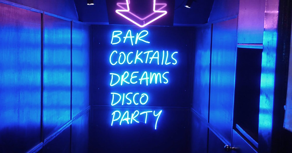 Neon sign: “Bar, Cocktails, Dreams, Disco, Party”